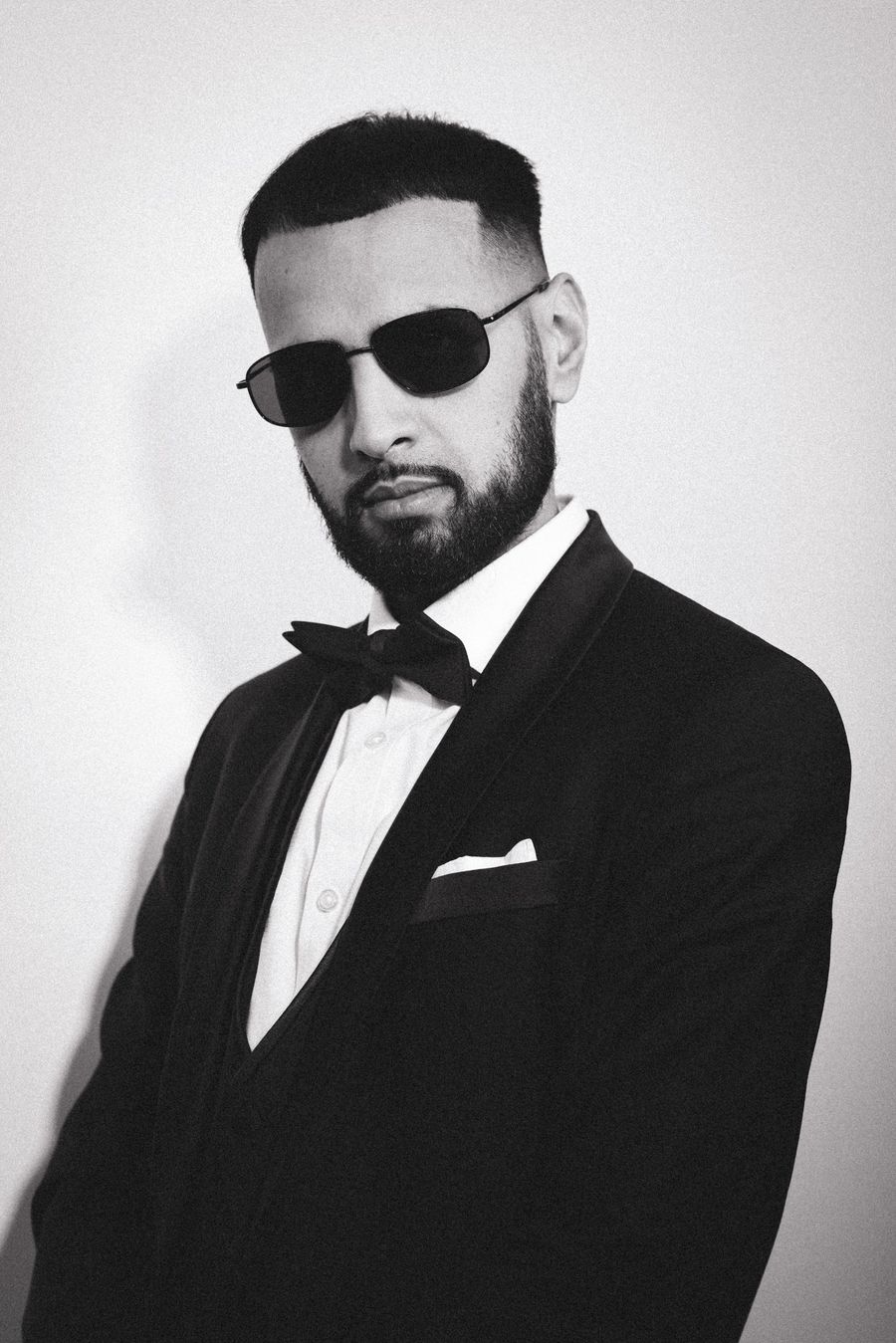 DJ Rish in a black velvet tuxedo, bow tie and sunglasses
