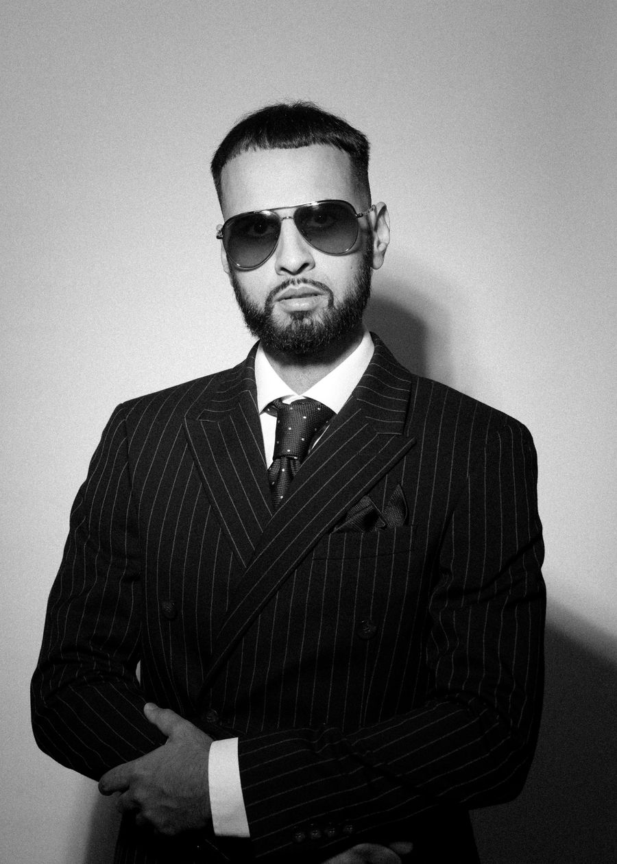 DJ Rish in a double-breasted pinstripe suit, black and white